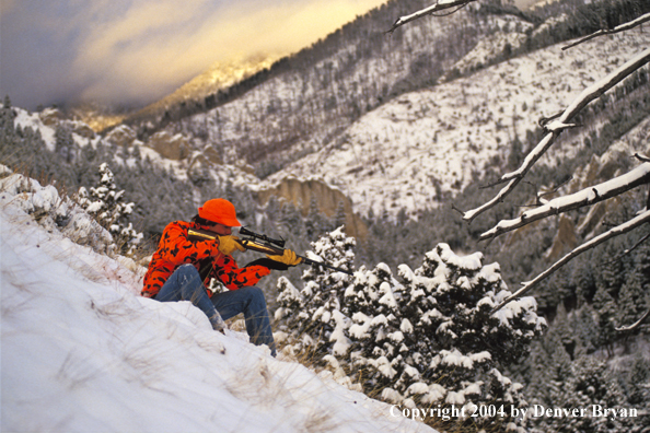 Big game hunter aiming/shooting.