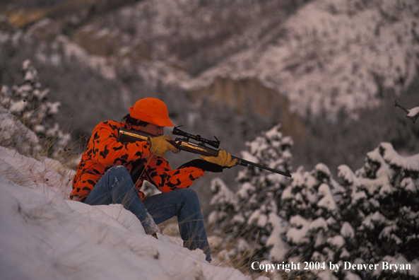 Big game hunter aiming/shooting.