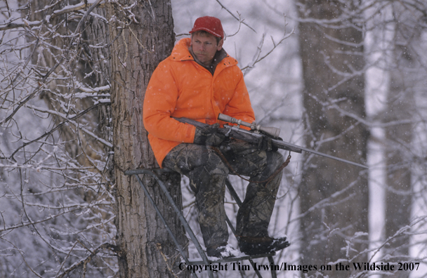 Big Game Hunter in tree stand during the winter.
