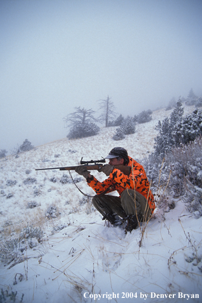 Big game hunter aiming/shooting.