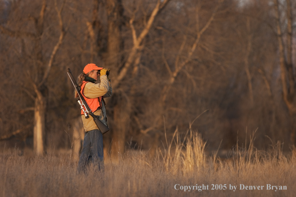 Woman big game hunter glassing for game.