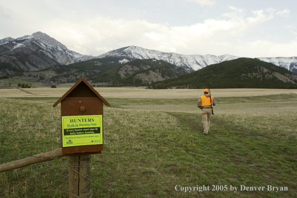 Hunting sign with hunter in background.