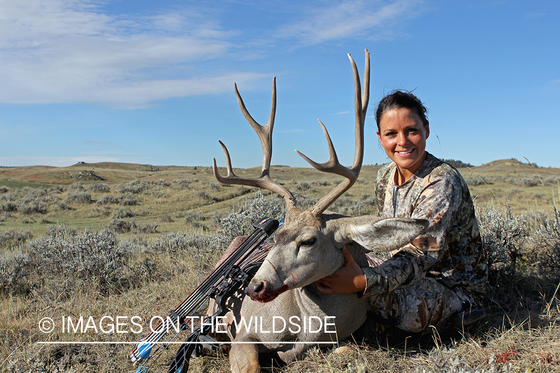 Woman hunter with bagged mule deer.