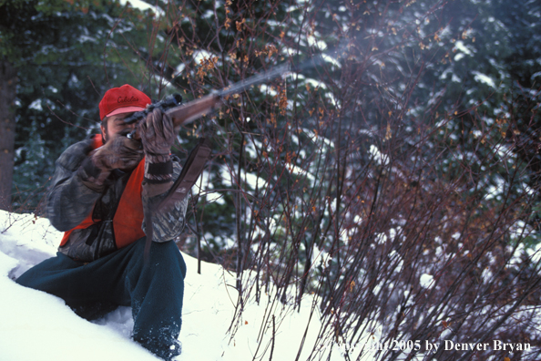 Big game hunter aiming/shooting.