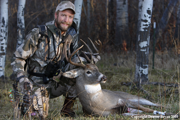 Bowhunter with bagged whitetail buck.