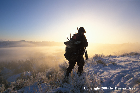 Big game hunter packing out kill.
