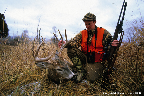 White-tailed deer hunter with downed deer