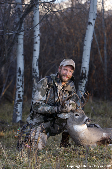 Bowhunter with bagged whitetail buck.