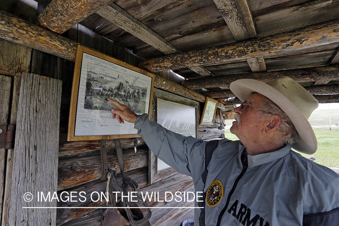 Dusty Don Waite pointing to old photo of Charlie Russell in Utica, Montana.