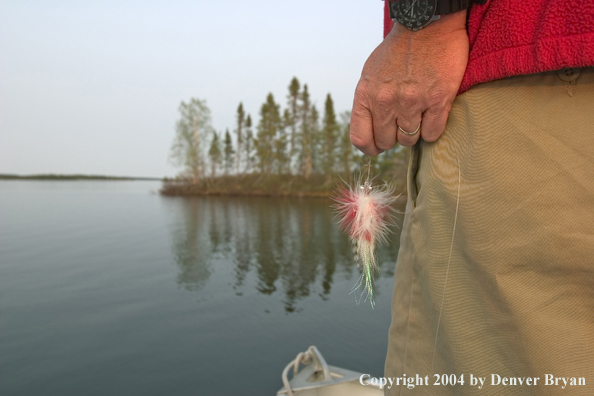Close-up of flyfisherman's hand with fly in hand.
