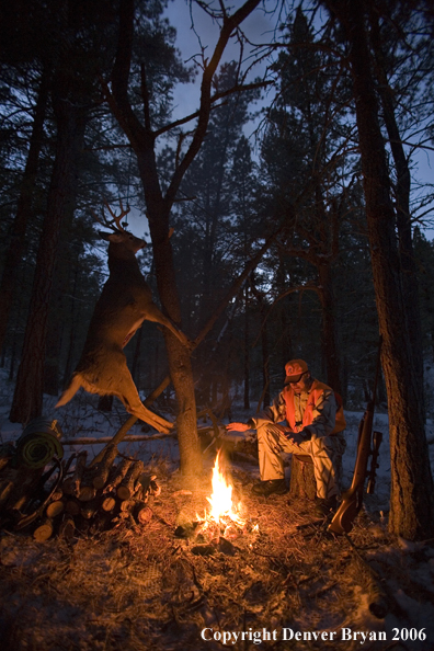 Deer hunter with bagged deer in camp in winter.  
