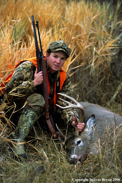 White-tailed deer hunter with downed deer