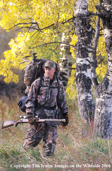 In-line muzzleloader hunter packing caped out mule deer.