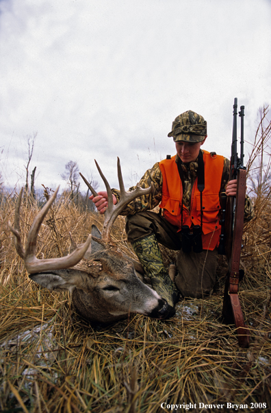 White-tailed deer hunter with downed deer