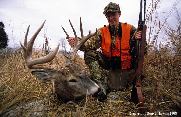 White-tailed deer hunter with downed deer