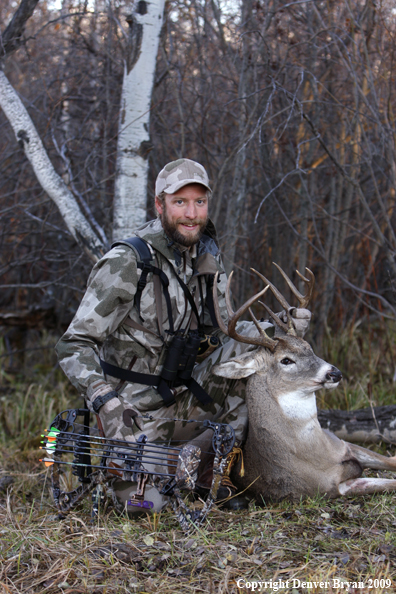 Bowhunter with bagged whitetail buck.