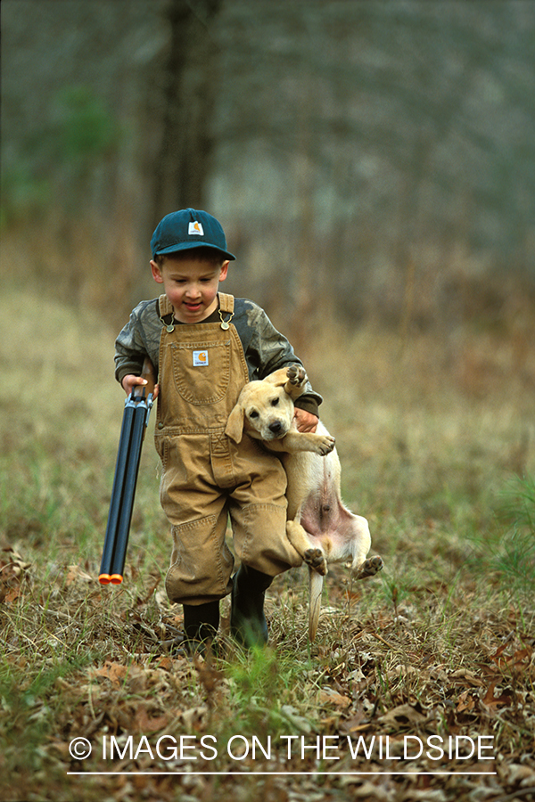 Young hunter with yellow Lab pup.