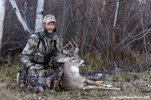 Bowhunter with bagged whitetail buck.