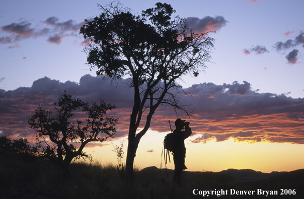 African hunter glassing at sunset.