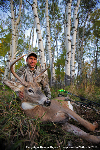 Bowhunter with downed white-tailed buck.