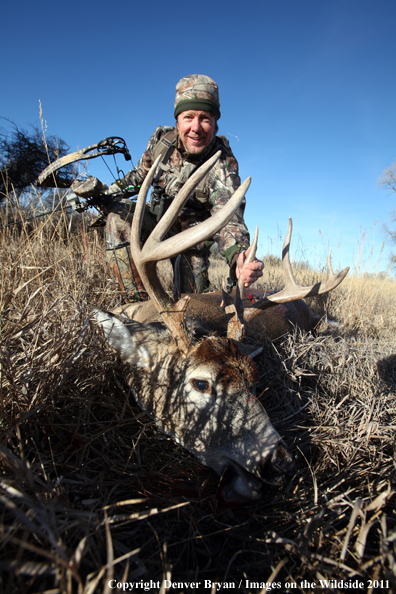 Bowhunter with bagged buck. 