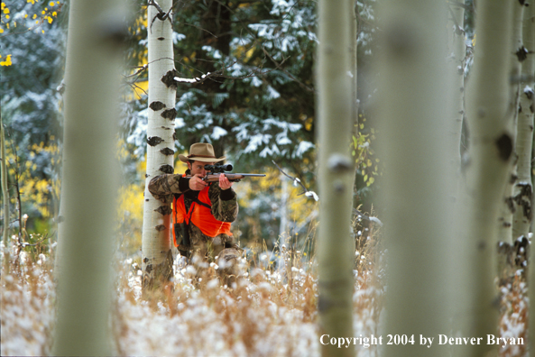 Big game hunter aiming/shooting.