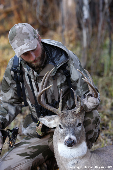 Bowhunter with bagged whitetail buck.