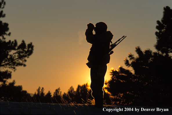Big game hunter glassing at sunrise/sunset.