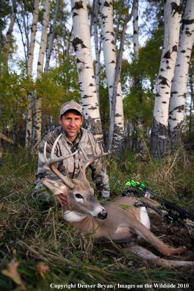 Bowhunter with downed white-tailed buck.
