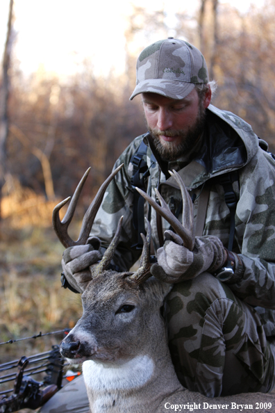 Bowhunter with bagged whitetail buck.