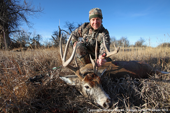 Bowhunter with bagged buck. 
