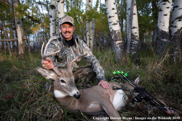 Bowhunter with downed white-tailed buck.
