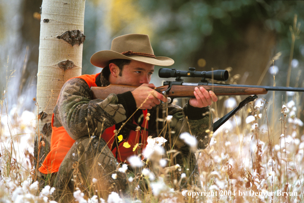 Big game hunter aiming/shooting.