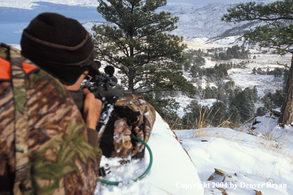 Big game hunter aiming/shooting.