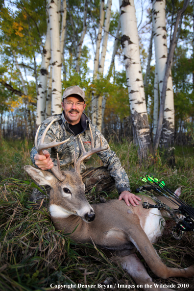 Bowhunter with downed white-tailed buck.
