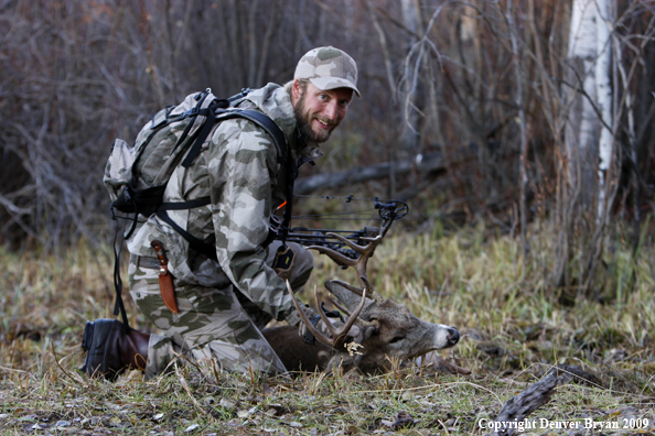 Bowhunter with bagged whitetail buck.