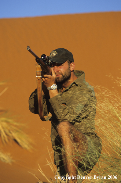 African hunter shooting at game.