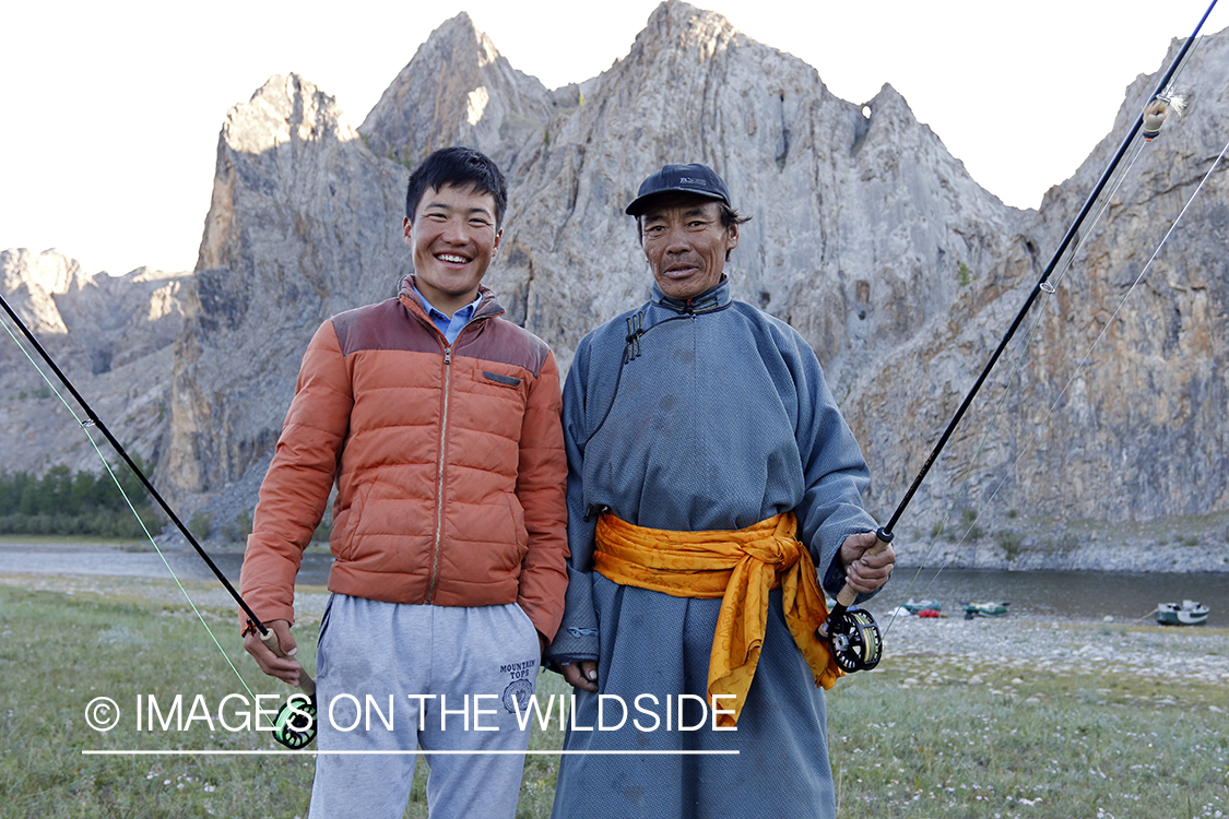 Young and elder Mongolian men with flyfishing rods.