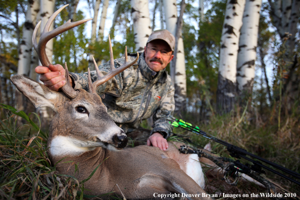 Bowhunter with downed white-tailed buck.