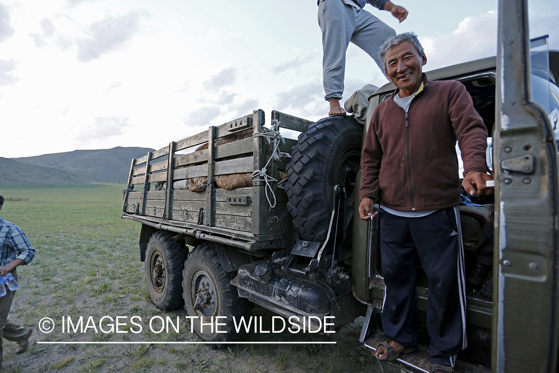 Mongolain men loading Russian transport truck on Mongolian steppe.