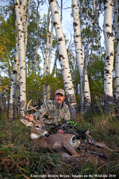 Bowhunter with downed white-tailed buck.