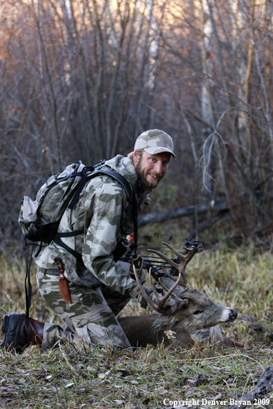 Bowhunter with bagged whitetail buck.