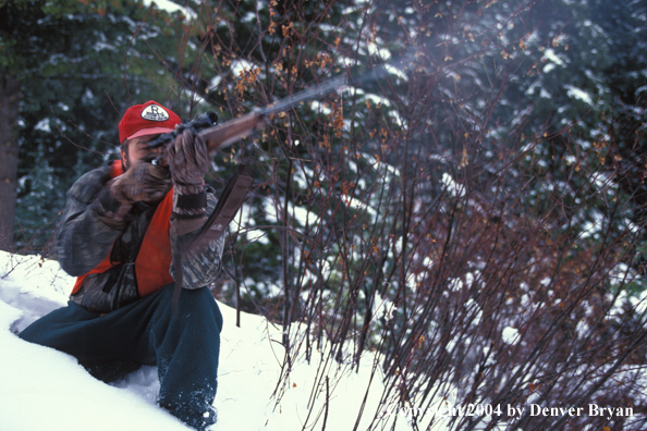 Big game hunter aiming/shooting.