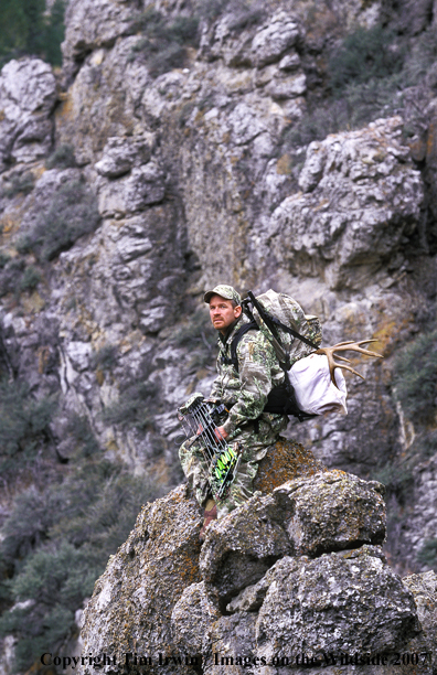 Bowhunter with mule deer horns on back.