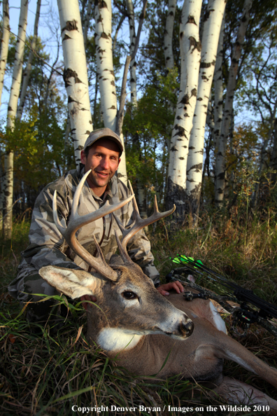 Bowhunter with downed white-tailed buck.