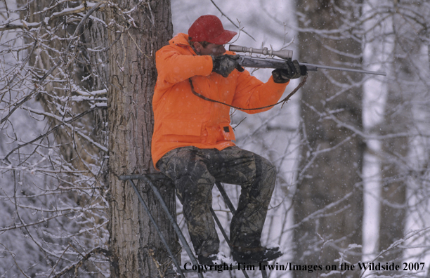 Big Game Hunter in tree stand during the winter.