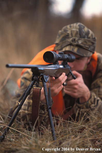 Big game hunter aiming/shooting.