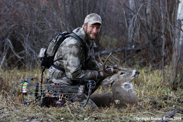 Bowhunter with bagged whitetail buck.