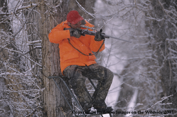 Big Game Hunter in tree stand during the winter.