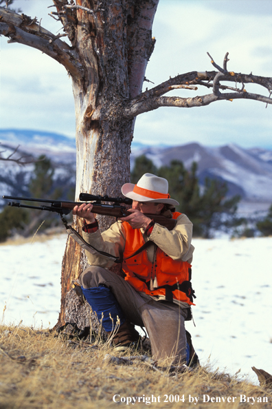 Big game hunter aiming/shooting.